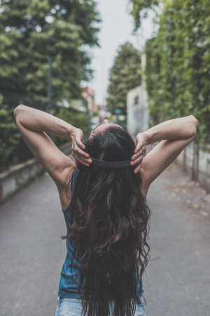 Beautiful girl with long hair posing in the city streetsの写真素材