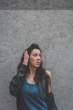 Beautiful girl with headphones listening to music in the city streetsの写真素材