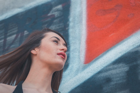 Beautiful young brunette with long hair posing in an industrial area