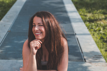 Beautiful young curvy girl in tank top posing in an urban context