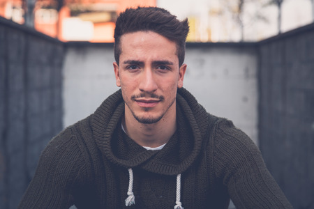 Young handsome man with short hair posing in an urban contextの写真素材