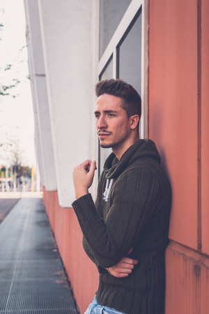 Young handsome man with short hair posing in an urban contextの写真素材