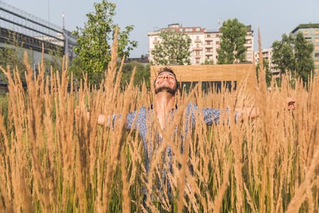 Young handsome man with short hair posing in a fieldの写真素材