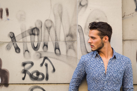 Young handsome man with short hair posing in the city streetsの写真素材