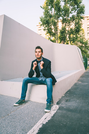 Young handsome man with short hair wearing a bow tie and posing in the city streetsの写真素材