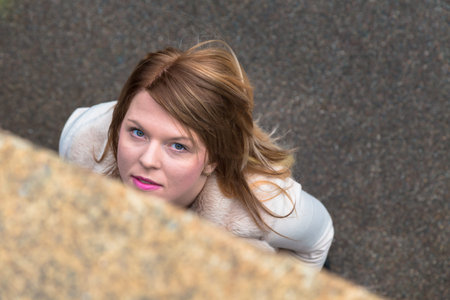 Top view of a beautiful young girl with long blond hair posing in an urban context