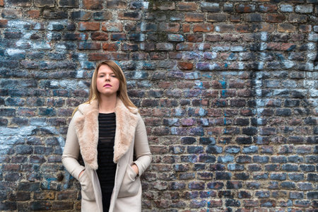 Beautiful young girl with long blond hair posing in an urban context