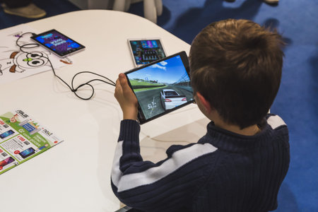 MILAN, ITALY - NOVEMBER 20: Child plays with tablet at G come giocare, trade fair dedicated to games, toys and children on NOVEMBER 20, 2015 in Milan.のeditorial素材