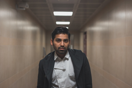 Portrait of a young handsome Indian man posing in a metro stationの写真素材