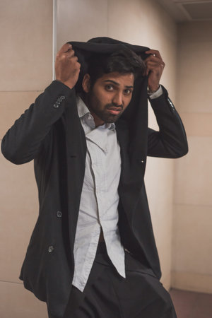 Portrait of a young handsome Indian man posing in a metro station