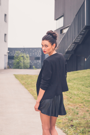 Gorgeous young brunette in black skirt posing in an urban contextの写真素材