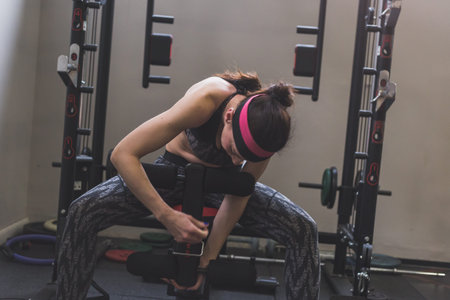 Beautiful young girl doing workout in the gym. Concept of health and fitness.