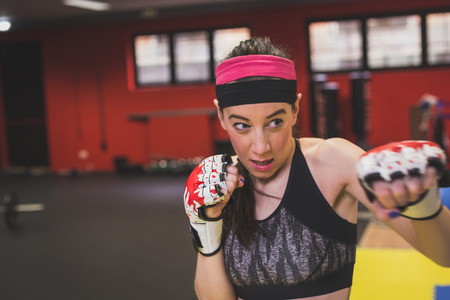 Beautiful young girl boxing in the gym. Concept of strenght and fitness.の写真素材