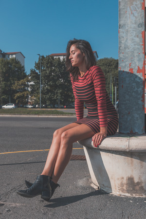 Beautiful young brunette with long hair posing in an urban contextの写真素材