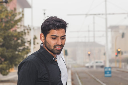 Portrait of a young handsome Indian man posing in an urban context