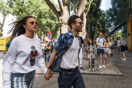 MILAN, ITALY - JUNE 21: Fashionable couple posing outside Armani fashion show building during Milan...
