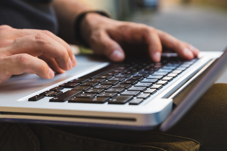 Detail of male hands working on laptopの写真素材