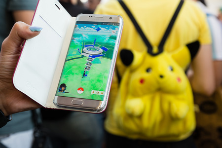 MILAN, ITALY - AUGUST 7, 2016: Hundreds of young people meet in a city park and take part in the Pokemon Go Tour, official event for hunting and catching Pokemons.のeditorial素材
