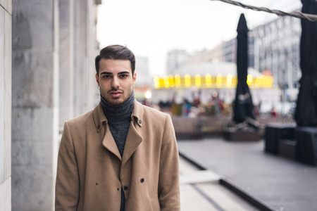 Beautiful young man with short hair posing in an urban contextの写真素材
