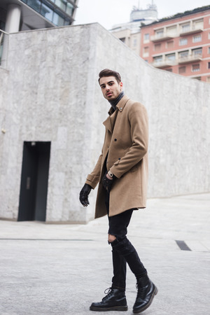 Beautiful young man with short hair posing in an urban contextの写真素材
