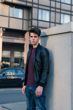 Beautiful young man with short hair posing in an urban contextの写真素材