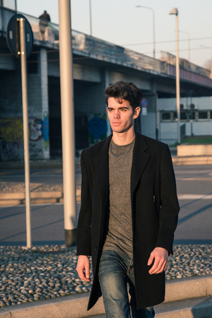 Beautiful young man with short hair posing in an urban contextの写真素材