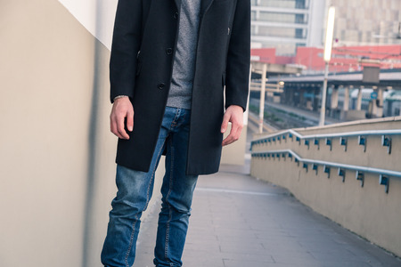 Detail of a beautiful young man with short hair posing in an urban contextの写真素材