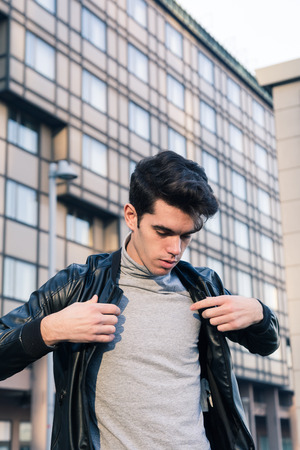 Beautiful young man with short hair posing in an urban contextの写真素材