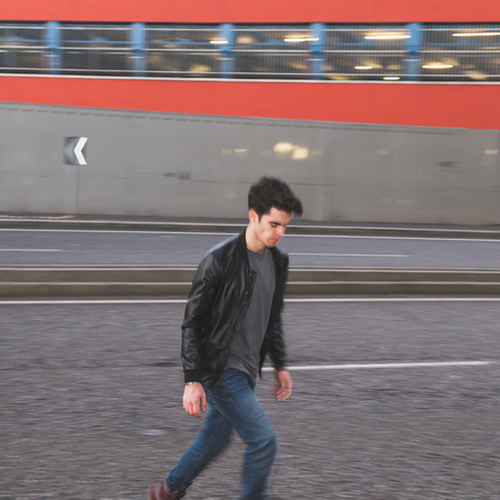 beautiful young man with short hair crossing the street intentionally blurredの写真素材