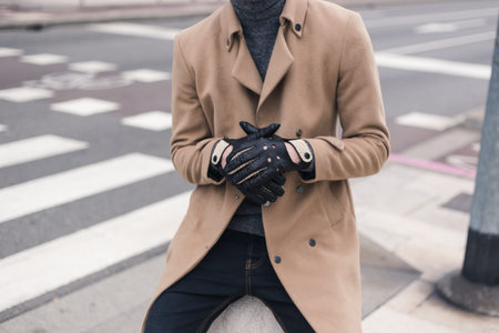 Detail of a young man wearing gloves and posing in an urban contextの写真素材