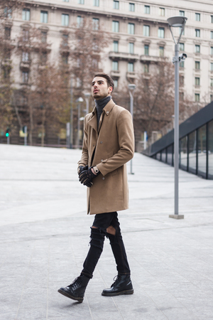 Beautiful young man with short hair posing in an urban contextの写真素材