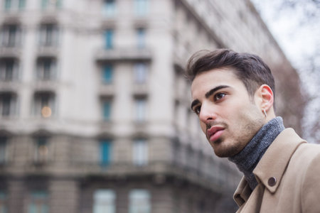 Beautiful young man with short hair posing in an urban context