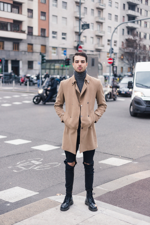 Beautiful young man with short hair posing in an urban contextの写真素材