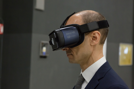 MILAN, ITALY - APRIL 21, 2017: Man tries virtual reality headset at Technology Hub, international event for innovative and futuristic technologies serving business.のeditorial素材