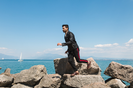 Handsome Indian man jumping in a vacation context. Street fashion and style.の写真素材