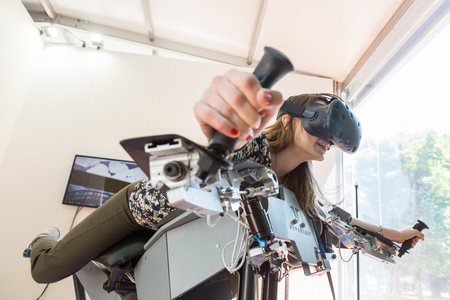 MILAN, ITALY - MAY 26: Girl tries virtual reality headset and flight simulator at Wired Next Fest, event dedicated to future, innovation and creativity on MAY 26, 2017 in Milan.のeditorial素材