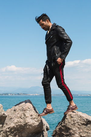 Handsome Indian man jumping in a vacation context. Street fashion and style.の写真素材