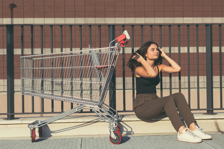 Young beautiful woman with long hair sitting by a cartの写真素材