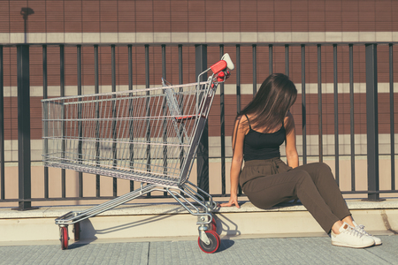 Young beautiful woman with long hair sitting by a cartの写真素材
