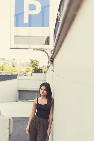 Young beautiful woman with long hair posing in an urban contextの写真素材