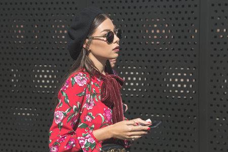 MILAN, ITALY - SEPTEMBER 20: Fashionable woman poses outside Gucci fashion show building during...