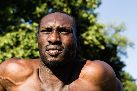 Athletic black man doing workout in a city park. Concept of healthy lifestyle.の写真素材