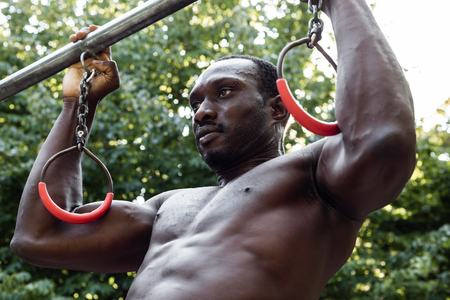 Athletic black man doing workout in a city park. Concept of healthy lifestyle.の写真素材