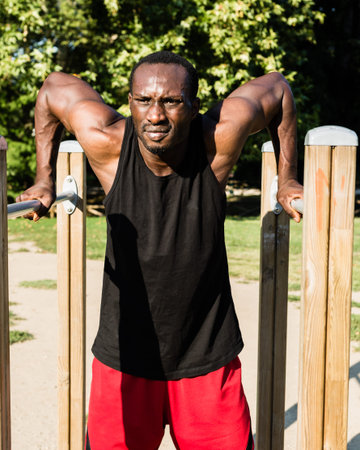 Athletic black man doing workout in a city park. Concept of healthy lifestyle.
