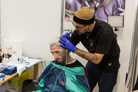 MILAN, iTALY - FEBRUARY 9, 2018: Professional tattooer works at Milan Tattoo Convention, international annual event dedicated to the world of tattoos and body painting in Milan, Italy.のeditorial素材
