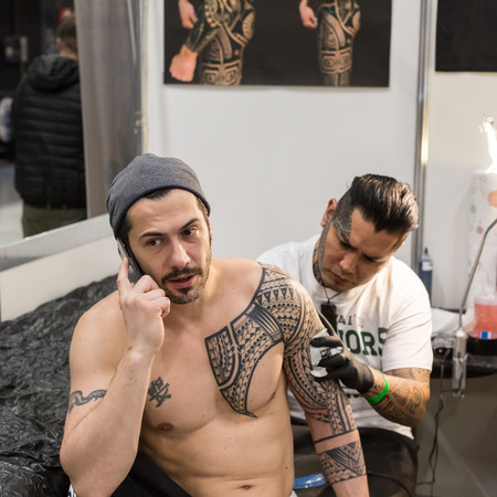 MILAN, iTALY - FEBRUARY 9, 2018: Professional tattooer works at Milan Tattoo Convention, international annual event dedicated to tattoos and body painting in Milan, Italy.のeditorial素材