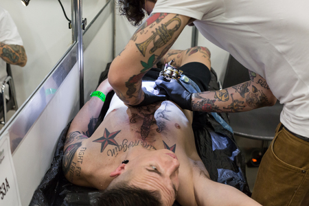 MILAN, iTALY - FEBRUARY 9, 2018: Professional tattooer works at Milan Tattoo Convention, international annual event dedicated to the world of tattoos and body painting in Milan, Italy.のeditorial素材