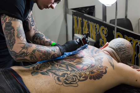 MILAN, iTALY - FEBRUARY 9, 2018: Professional tattooer works at Milan Tattoo Convention, international annual event dedicated to tattoos and body painting in Milan, Italy.のeditorial素材
