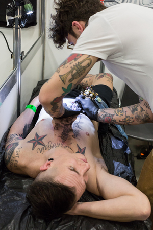 MILAN, iTALY - FEBRUARY 9, 2018: Professional tattooer works at Milan Tattoo Convention, international annual event dedicated to the world of tattoos and body painting in Milan, Italy.のeditorial素材