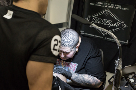 MILAN, iTALY - FEBRUARY 9, 2018: Professional tattooer works at Milan Tattoo Convention, international annual event dedicated to the world of tattoos and body painting in Milan, Italy.のeditorial素材